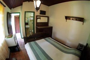 a bedroom with a bed and a sink and a mirror at OYO Pousada do Wagner, Rio das Ostras in Rio das Ostras