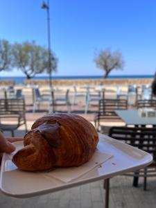 Eine Person hält ein Brot auf einem Teller. in der Unterkunft Wine Suite b&b in Torricella