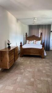 1 dormitorio con 1 cama grande y vestidor de madera en Habitacion con Jacuzzy en Dani's Guest House, en Las Galeras