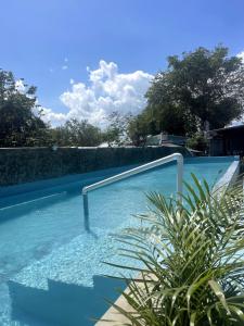 una piscina con un pasamanos en el agua en Habitacion con Jacuzzy en Dani's Guest House, en Las Galeras 6 fotos más