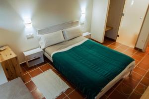 sypialnia z dużym łóżkiem i zielonym kocem w obiekcie Hotel Rural Las Encinas w mieście Santa María de Redondo