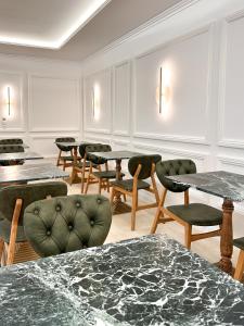 a room with tables and chairs and a bunch of tables at Armata Boutique Hotel in Spetses