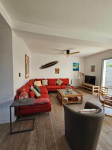 un salon avec un canapé rouge et une table dans l'établissement Villa OCEAN, à Lacanau-Océan