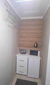 a small kitchen with a stove and a microwave at Cronin Luxury accommodation Room 4 in Kimberley +22 photos