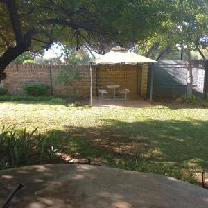 a backyard with a table and an umbrella at Cronin Luxury accommodation Room 4 in Kimberley