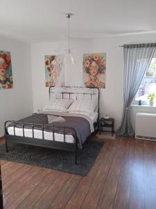 a bedroom with a bed and a wooden floor at Apartament Magnolia - Centrum in Nysa