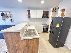 una cocina con fregadero y refrigerador en Amara201-Hermoso Apartamento comodo y amplio en Laureles, en Armenia