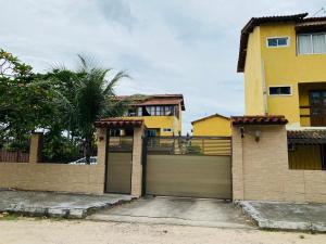 una casa con una puerta de garaje delante de ella en Apt 1000 metros da praia do trevo, en Rio das Ostras