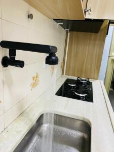 una cocina con estufa y fregadero en Apt 1000 metros da praia do trevo, en Rio das Ostras 13 fotos más