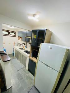 Una cocina con un refrigerador blanco en una habitación. en Apt 1000 metros da praia do trevo, en Rio das Ostras