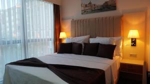 a bedroom with a large bed with a large window at Karadeniz Hotel Çorlu in Corlu