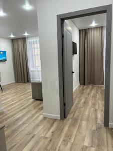 una porta aperta in una camera con pavimento in legno di Апартаменты в ЖК Атлант a Kökşetaw