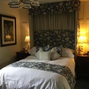 ein großes Bett in einem Schlafzimmer mit zwei Lampen in der Unterkunft The Brownlow Arms Inn in Grantham