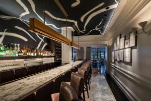 a bar in a restaurant with a long counter and chairs at The Ritz-Carlton New York, Central Park in New York