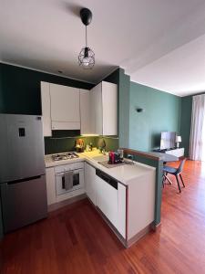a kitchen with white appliances and green walls at La dimora del Marchese in Duomo in Milan +2 photos