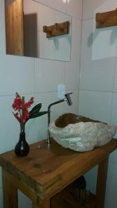 un bagno con lavandino in pietra su un tavolo in legno di Cabana refúgio da juruti 08 a Cunha