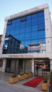 乔尔卢Karadeniz Hotel Çorlu的前面有长椅的大型玻璃建筑