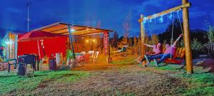 CucunubáにあるLa Tata cabaña y zona de campingの夜の公園のブランコに座っている二人の女性