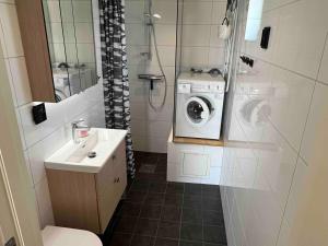 a bathroom with a washing machine and a sink at Stuga Varberg Södranäs in Varberg