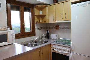 una cucina con un lavello e un frigorifero bianco di La Torreta a Gerbe Altre 7 foto