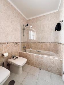 a bathroom with a tub and a toilet and a sink at Casa 33 - Idyllisches Reihenhaus mit Innenhof in São Martinho do Porto