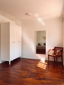 an empty room with a chair and a mirror at Casa 33 - Idyllisches Reihenhaus mit Innenhof in São Martinho do Porto