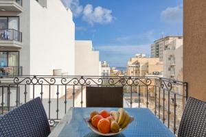 a bowl of fruit on a table on a balcony at La Casa Provenza in St Paul's Bay