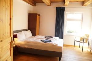1 dormitorio con 1 cama con ventana y silla en Romantik-Ferienhaus -Vier Sterne- idyllische Lage nähe Berlin, en Marienwerder 12 fotos más