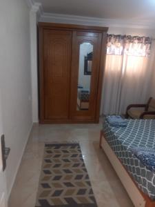 a bedroom with a bed and a dresser and a mirror at Luxury Villa in North Coast Mediterranean in Dawwār Abū Maḩrūs