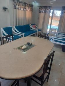 a room with a table and chairs and a couch at Luxury Villa in North Coast Mediterranean in Dawwār Abū Maḩrūs +9 photos