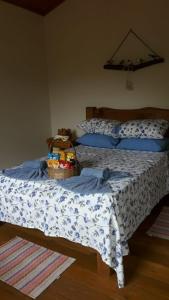 a bedroom with a bed with a basket of food on it at Cabana refúgio do tico tico 07 in Cunha