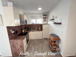 a kitchen with white cabinets and wooden counter tops at VIRCATION Apartments in Vir