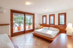 Un dormitorio con una cama y una ventana grande. en Resort Ninfea San Pellegrino Terme, en San Pellegrino Terme 81 fotos más