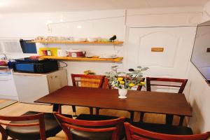 a kitchen with a wooden table and chairs and a table and a kitchen at Hongdae 3mins, Q House in Seoul