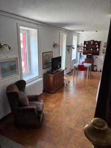 a living room with a chair and a television at Ester Lakehouse, graziosa casa indipendente in Lierna