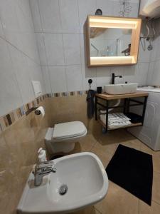 a bathroom with a sink and a toilet and a mirror at Charming one bedroom apartment in Vrsar old town in Vrsar