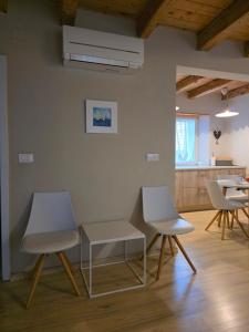 two white chairs and a table in a room at Charming one bedroom apartment in Vrsar old town in Vrsar