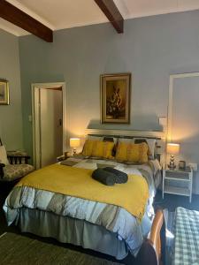 a bedroom with a large bed with a yellow blanket at Glen House in Brenton-on-Sea