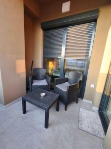 a living room with chairs and a table and a window at Bukefal apartment in Skopje +4 photos