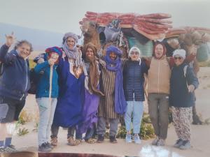 un gruppo di persone che si trovano davanti a un cartello di Camp Les Bedouins iriki a Bou Guir
