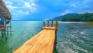 a wooden dock in the water on a lake at Casa Luna in El Remate