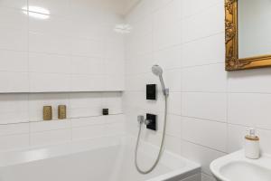 a white bathroom with a shower and a sink at SOFAGOLD Nadštandardný apartmán s veľkou terasou in Košice +26 photos
