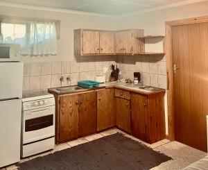 a kitchen with wooden cabinets and white appliances at Glen House in Brenton-on-Sea