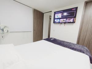 a bedroom with a bed with a tv on the wall at Apto zona norte a 20 min del buena vista in Barranquilla