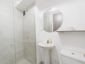 a white bathroom with a sink and a shower at Apto zona norte a 20 min del buena vista in Barranquilla +15 photos