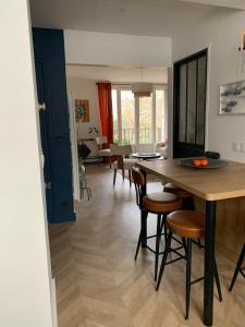 a kitchen and living room with a table and chairs at La fontaine à Chantilly in Chantilly