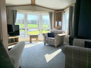 a living room with a couch and chairs and a television at Penny in Whithorn