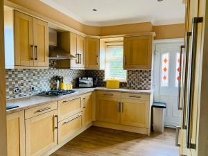 a kitchen with wooden cabinets and a stove top oven at Home like 3 bed house Sheffield in Sheffield