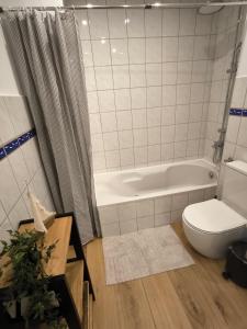 a bathroom with a tub and a toilet and a sink at Schleizauber Ferienwohnung mit Wasserblick und einer großzügigen Terrasse in Schleswig +6 photos