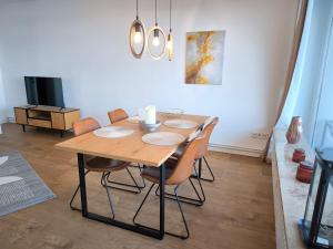 a dining room with a wooden table and chairs at Schleizauber Ferienwohnung mit Wasserblick und einer großzügigen Terrasse in Schleswig